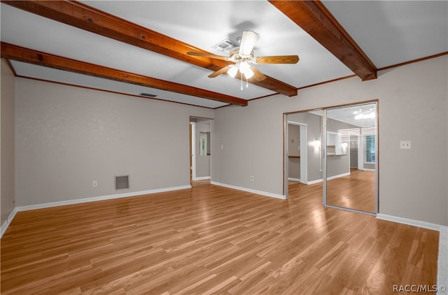 empty room featuring beamed ceiling, light hardwood / wood-style flooring, and ceiling fan