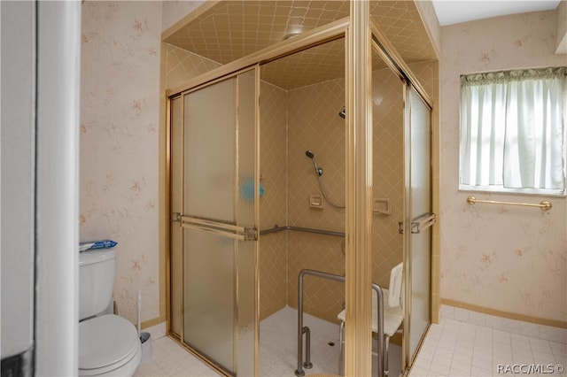 bathroom with tile patterned flooring, toilet, and walk in shower