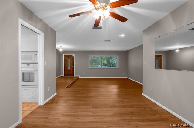 unfurnished living room featuring ceiling fan and light hardwood / wood-style flooring