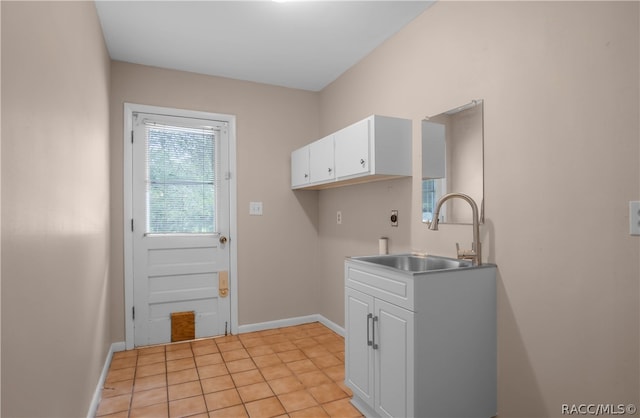 clothes washing area featuring cabinets, light tile patterned flooring, electric dryer hookup, and sink