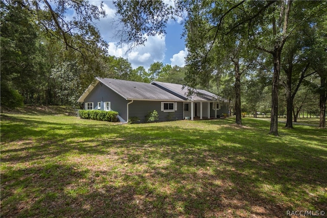 view of side of home with a yard