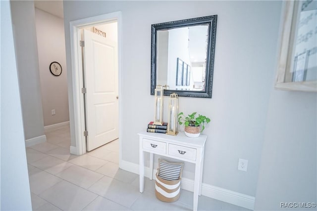 corridor featuring baseboards and light tile patterned flooring