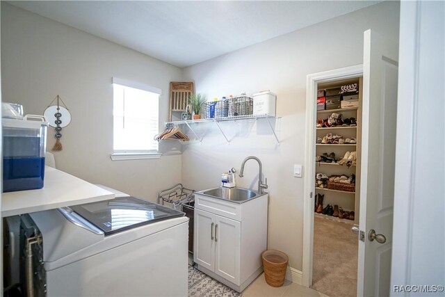 laundry room with a sink, light colored carpet, and washer and clothes dryer