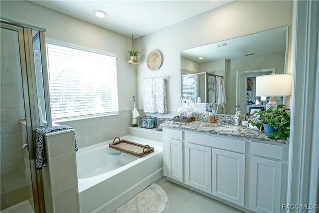 full bathroom featuring visible vents, a shower stall, tile patterned floors, a bath, and vanity