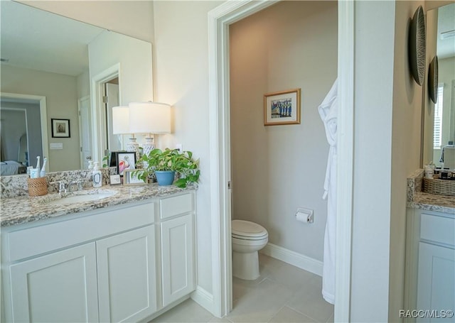 bathroom with tile patterned flooring, toilet, vanity, and baseboards