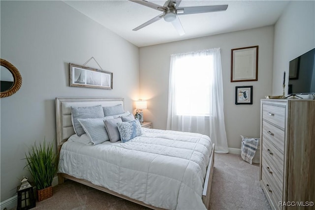 carpeted bedroom with ceiling fan and baseboards