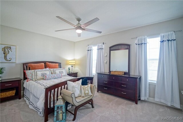 bedroom featuring light carpet and a ceiling fan