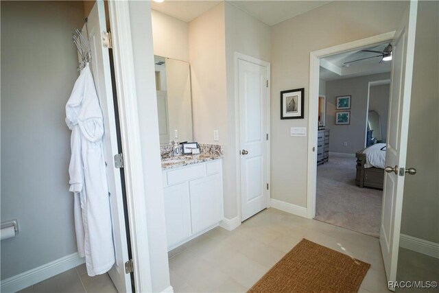 bathroom with vanity, a ceiling fan, and baseboards