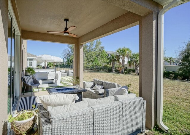 view of patio with an outdoor living space, a ceiling fan, and fence