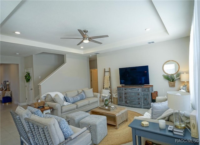 living room with recessed lighting, visible vents, and a raised ceiling