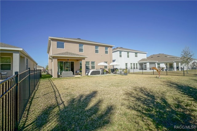 back of property featuring a fenced backyard, a residential view, and stucco siding