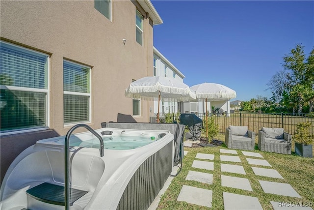 view of patio / terrace featuring a hot tub and fence