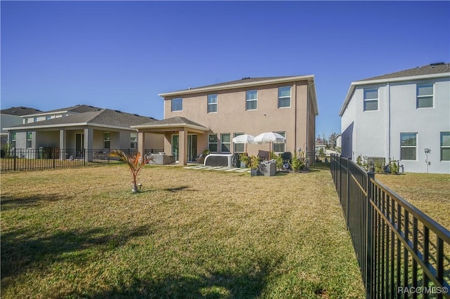 rear view of property with a residential view, stucco siding, a lawn, and fence