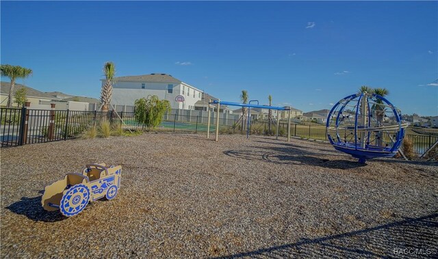 communal playground featuring a residential view and fence