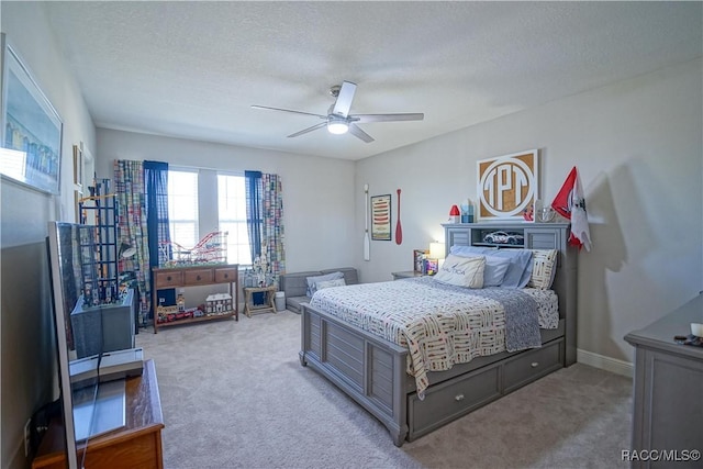 bedroom featuring baseboards, light colored carpet, ceiling fan, and a textured ceiling