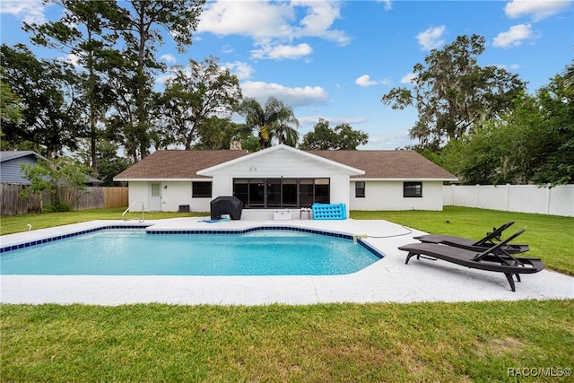 view of swimming pool with a yard, a patio, a sunroom, and a grill