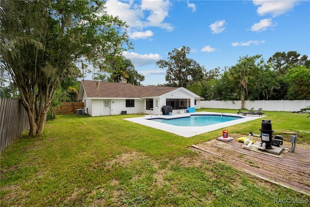 rear view of house with a fenced in pool, a yard, and cooling unit