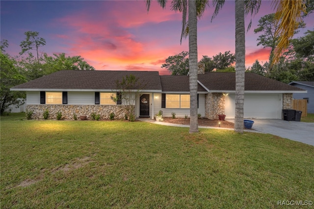 ranch-style house featuring a lawn and a garage