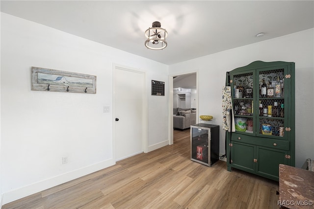 interior space with a notable chandelier, light hardwood / wood-style floors, and beverage cooler