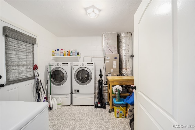 washroom with a textured ceiling and independent washer and dryer