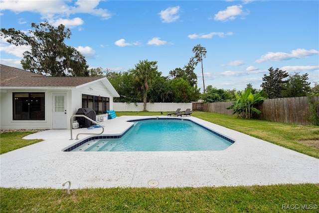 view of swimming pool with a patio, a sunroom, and a lawn