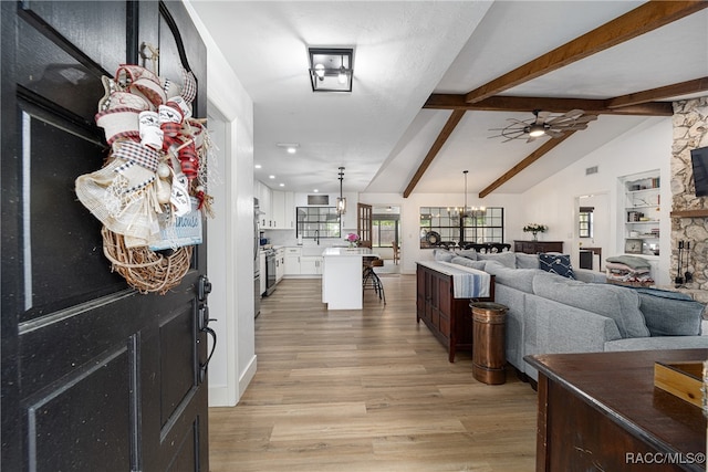 interior space featuring built in shelves, vaulted ceiling with beams, light hardwood / wood-style floors, and ceiling fan