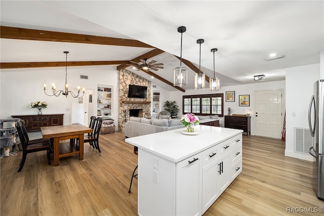 kitchen with vaulted ceiling with beams, light hardwood / wood-style flooring, white cabinets, and a kitchen island