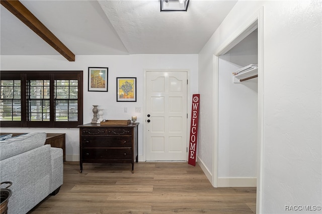 foyer with beam ceiling and hardwood / wood-style floors