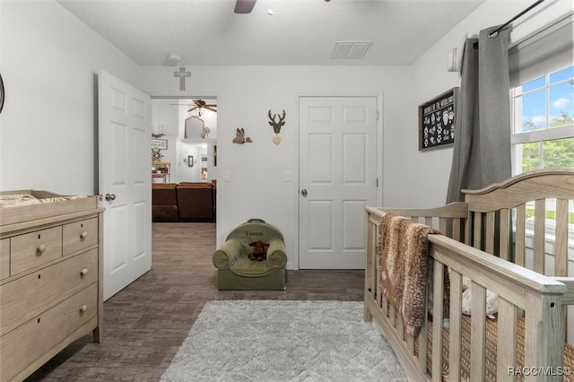 5317 W Tortuga Loop, Lecanto, FL 34461 - bedroom with wood finished floors, a ceiling fan, and a crib