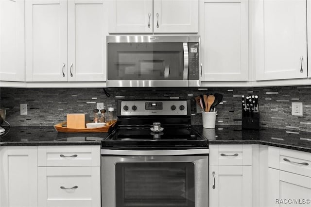 5317 W Tortuga Loop, Lecanto, FL 34461 - kitchen with appliances with stainless steel finishes, white cabinets, backsplash, and dark stone countertops