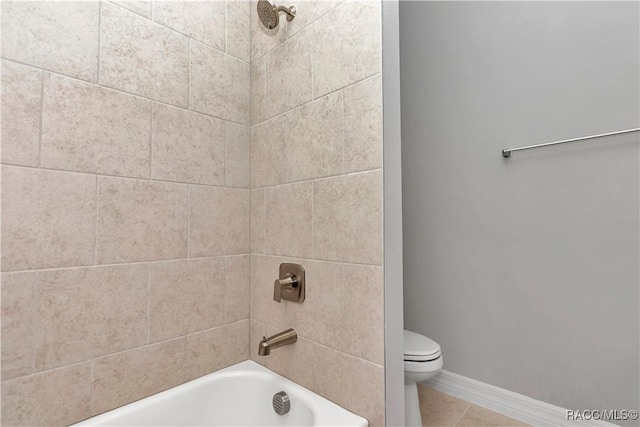 bathroom with tiled shower / bath combo and toilet