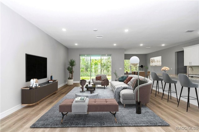 living room with sink and light hardwood / wood-style floors