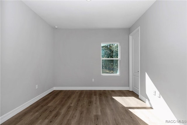 empty room with dark hardwood / wood-style flooring