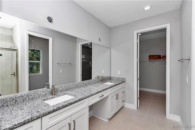 bathroom featuring vanity, tile patterned flooring, and a shower with door