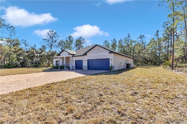 single story home featuring a front lawn and a garage