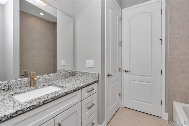 bathroom with a bathing tub, tile patterned floors, and vanity