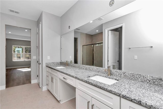 bathroom featuring an enclosed shower, vanity, and tile patterned flooring