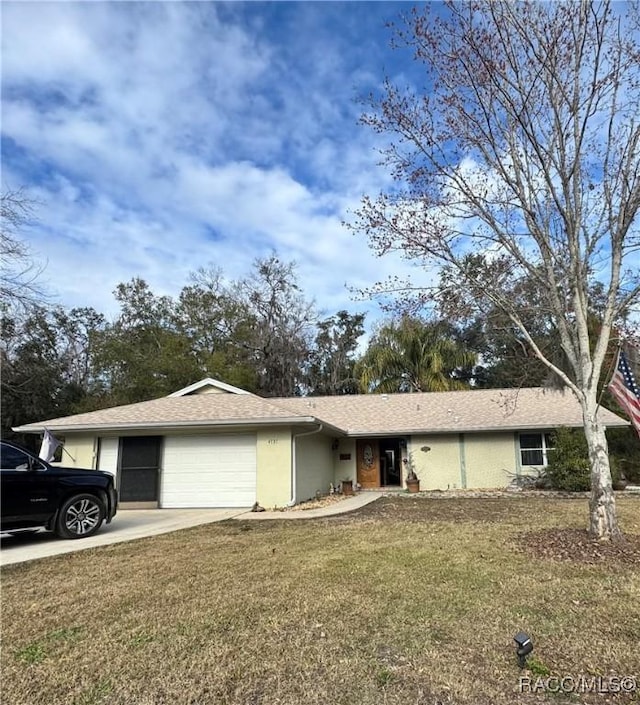 ranch-style home featuring a garage and a front lawn