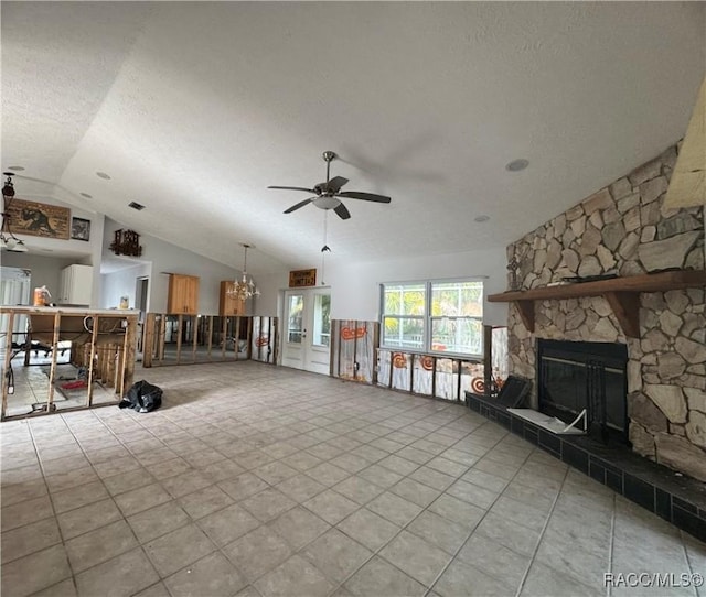 living room featuring ceiling fan, lofted ceiling, a stone fireplace, and a textured ceiling