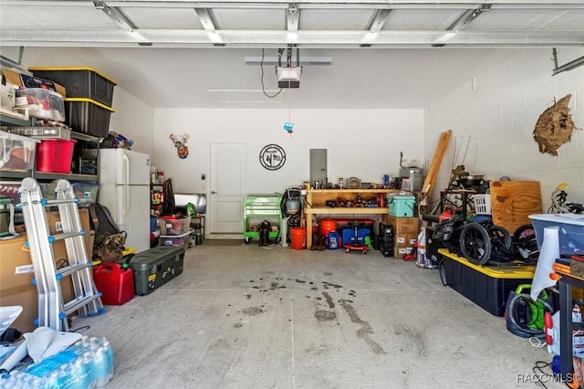 garage featuring a garage door opener and white refrigerator