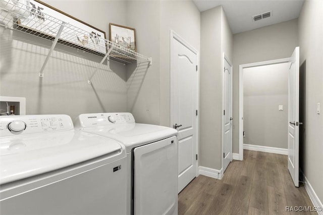 laundry area featuring wood-type flooring and washer and dryer