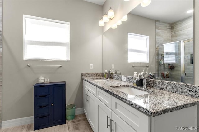 bathroom featuring vanity and a shower with door