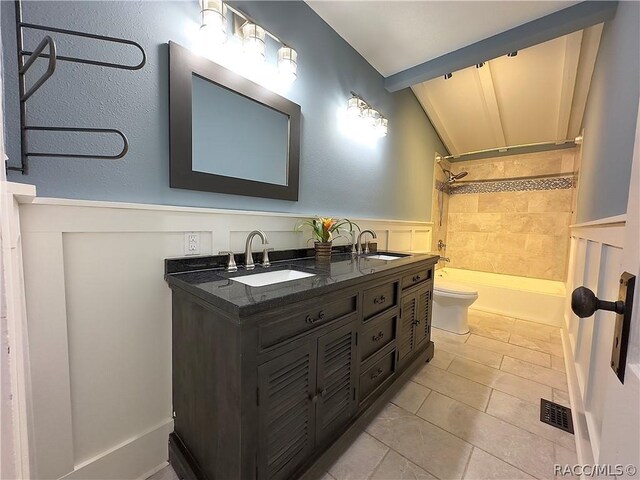 full bathroom featuring vanity, washtub / shower combination, tile patterned flooring, toilet, and lofted ceiling