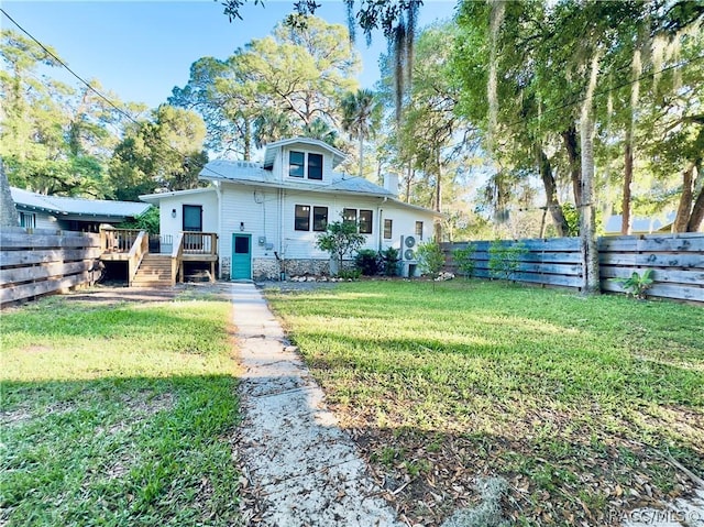 rear view of property with a yard and a deck