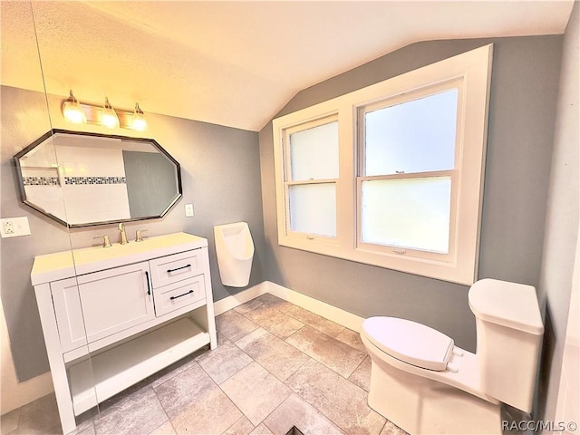 bathroom with vanity, toilet, and lofted ceiling