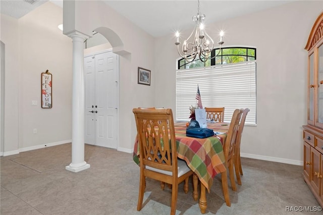 dining area featuring light tile patterned floors, a chandelier, and decorative columns