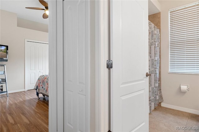 bathroom featuring ceiling fan, tile patterned floors, and curtained shower