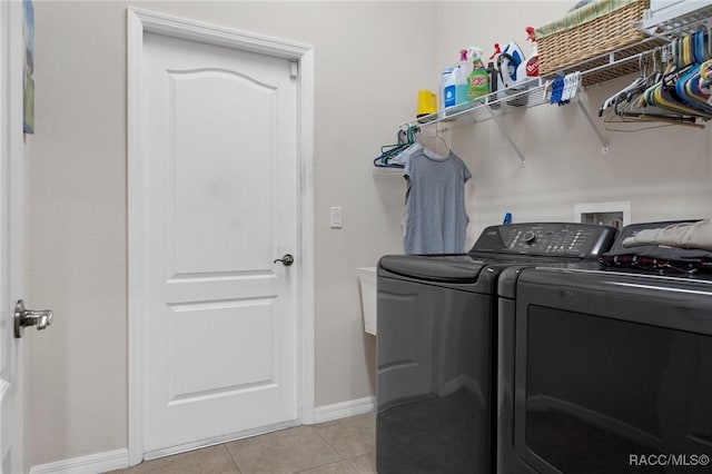 clothes washing area with light tile patterned floors and independent washer and dryer