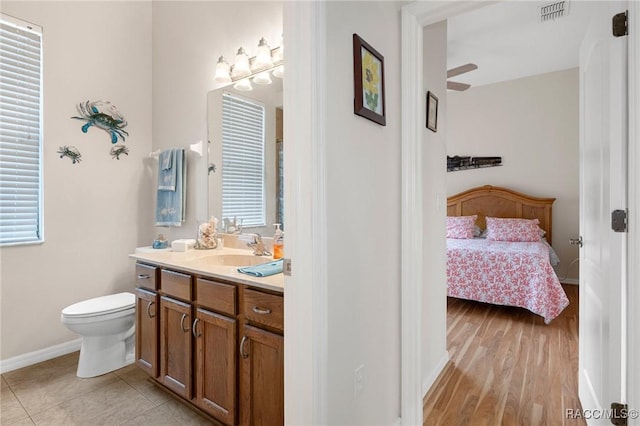 bathroom featuring ceiling fan, hardwood / wood-style flooring, toilet, and vanity