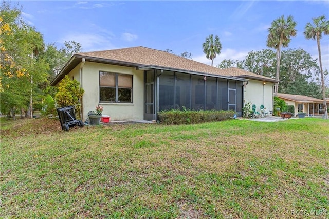 back of property featuring a sunroom and a lawn